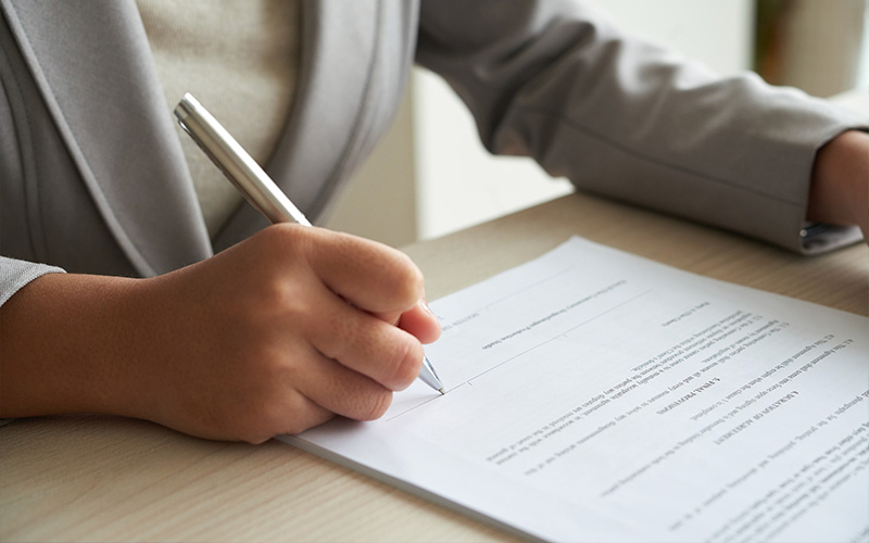 Close-up of businesswoman signing a contract.