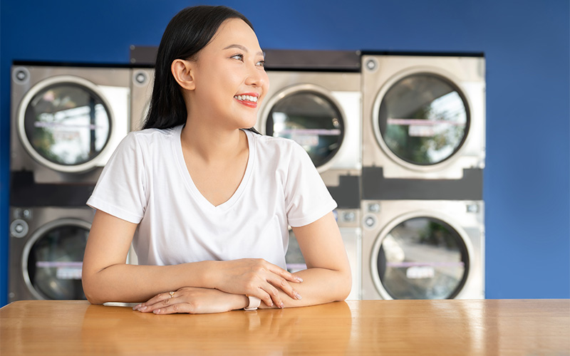 Person sitting at table in laundromat.
